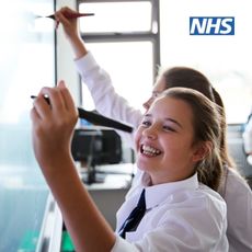 School pupils writing on a whiteboard