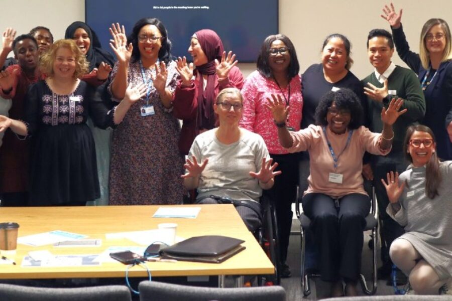Group shot of ICDP alumni and participants smiling and waving