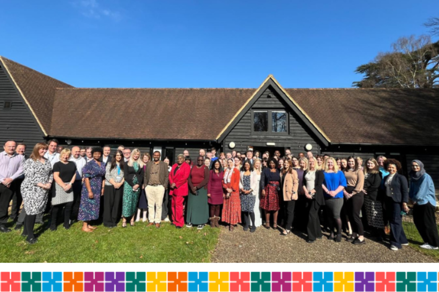 Participants of the ESLP and ADDS leadership development programmes standing outside the front of a building celebrating completing their courses.