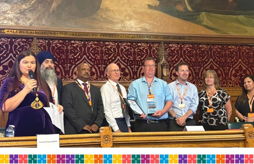 A row of people stood in the houses of parliament receiving awards