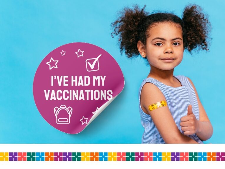 Child giving thumbs up after vaccination. Plaster on arm.