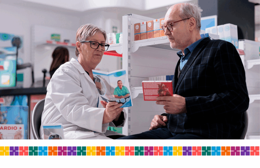 Community pharmacist providing health advice to a patient looking at leaflet together