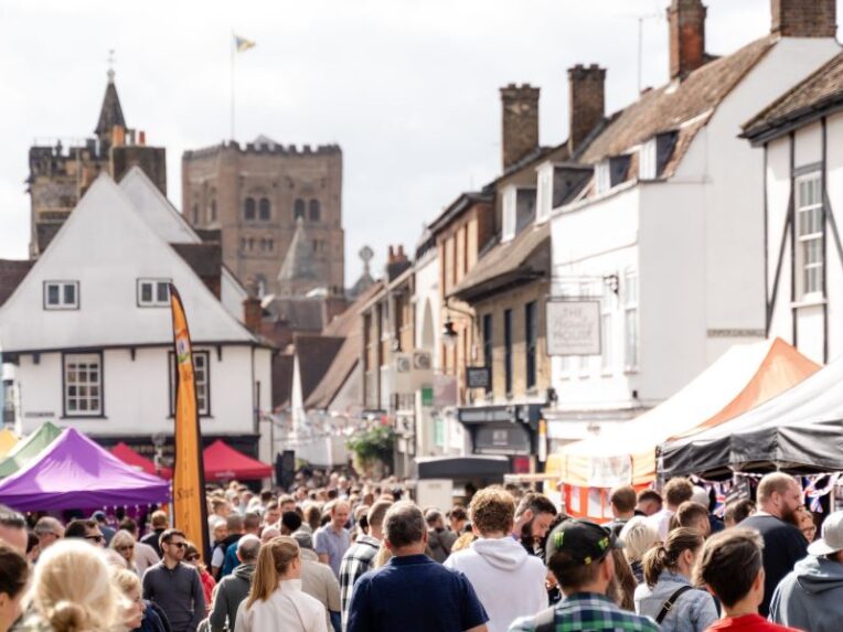 Crowd of people in a busy street market with old building all around